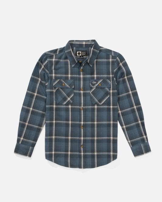 The Salty Crew Daybreak Boys Flannel in Channel Blue features mid-weight twill, blue/white/tan yarn-dyed plaid, button-up front, long sleeves, dual chest pockets with button flaps, and a patch above the left pocket.