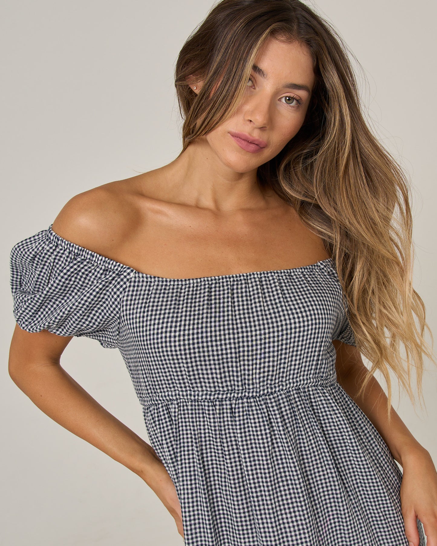 A woman with long, wavy hair is wearing the Salty Crew Fresh Catch Mini Dress in True Navy. She is looking at the camera with a neutral expression against a plain light background.