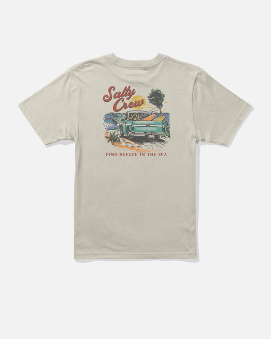 The Salty Crew Truck Bed Boys Tee in Bone features a beach scene with palm trees and a wooden boat screenprinted on soft, combed ringspun cotton for all-day comfort. “Salty Crew” is displayed at the top, while “Find Refuge in the Sea” is printed below the illustration.