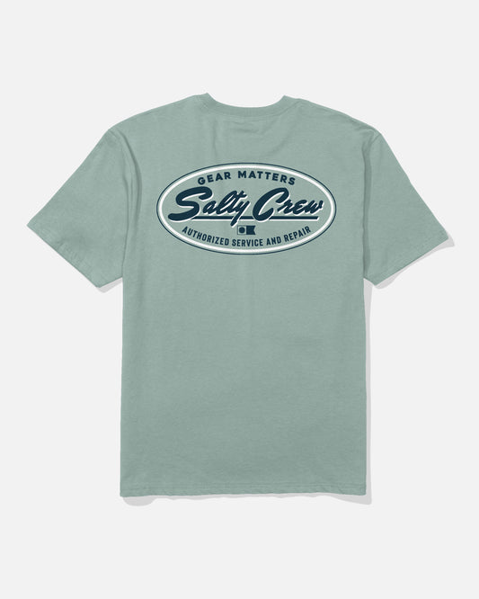 A washed steel grey Service Heavyweight Tee by Salty Crew shown from the back, featuring a large oval logo with "Gear Matters," "Salty Crew," and "Authorized Service and Repair" in navy blue and white text.
