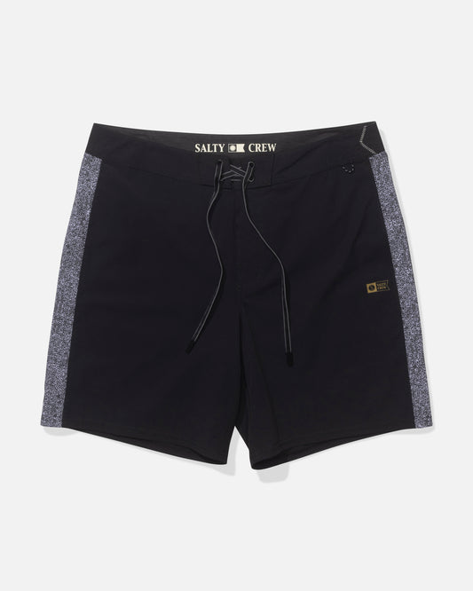 The Salty Crew Channel 18" Apex Boardshort in Pirate Black features dark gray side panels, a lace-up front, quick-dry performance fabric, and a yellow-black logo patch with the Salty Crew name in white on the waistband.