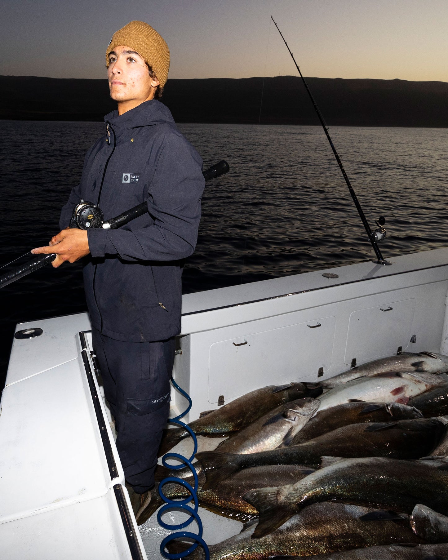 Candid photo of fishing in the Long Range Jacket - Black.