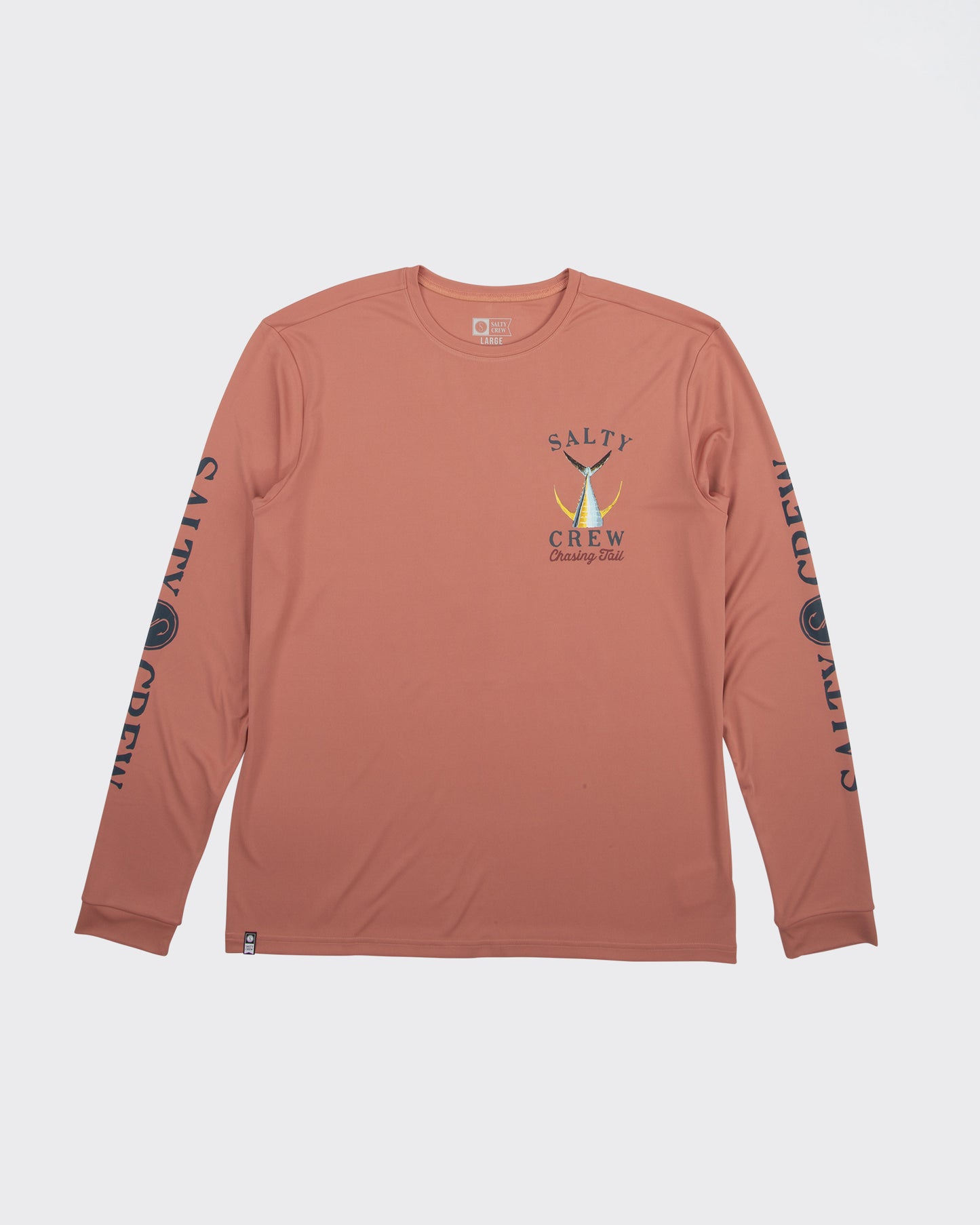 The Salty Crew Tailed Long Sleeve Sunshirt - Coral is made from recycled polyester with UPF 50+ protection, features SALTY CREW prints on both sleeves, and a small fish graphic with "Salty Crew Chasing Tail" on the left chest.