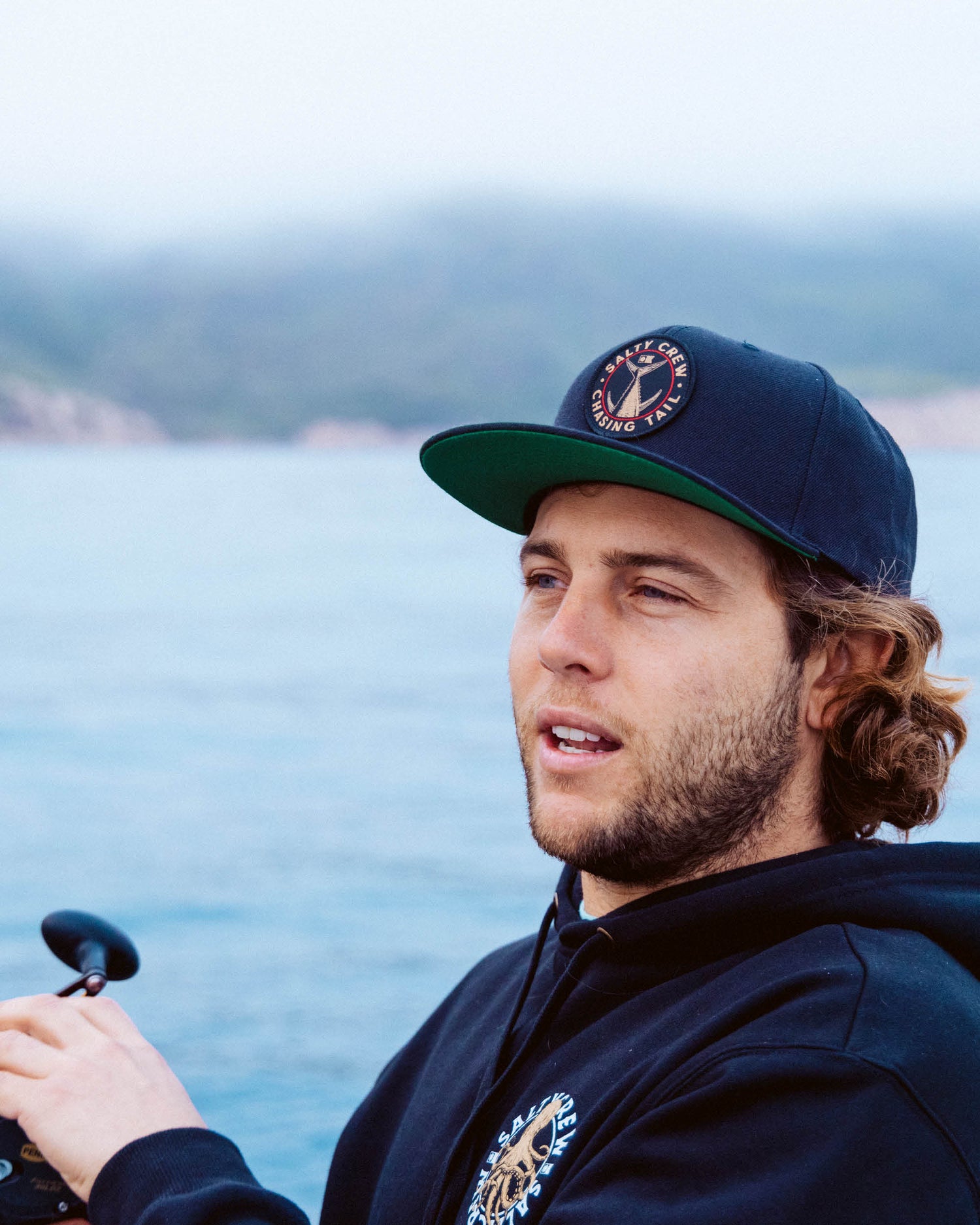 Lifestyle shot of the Tailgate 6 Panel Hat - Black. 