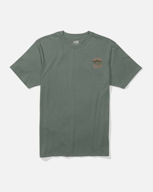 Salty Crew’s Jimmy Crew Tee in Laurel Wreath is a green, short-sleeve cotton shirt with a small, round colorful patch on the left chest featuring an illustrated mountain scene and the word “WILDERNESS.” This combed ringspun tee is shown laid flat against a white background.