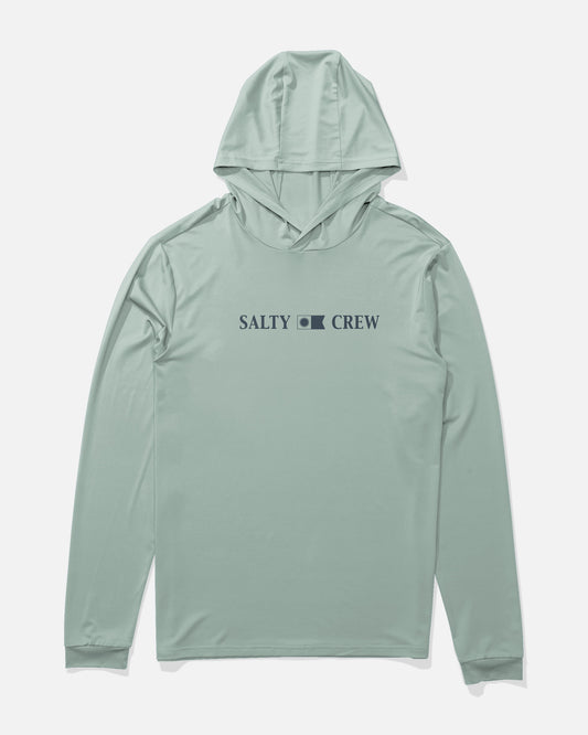 The Salty Crew Rail Hood Sunshirt in Aqua Grey is a light green, long-sleeve performance shirt featuring a hood and SALTY CREW’s signature wave logo printed in navy blue across the chest. Made from recycled polyester for sustainability, it includes moisture-wicking technology and provides UPF 50+ sun protection, ensuring comfort and coverage. The shirt is displayed on a plain white background.