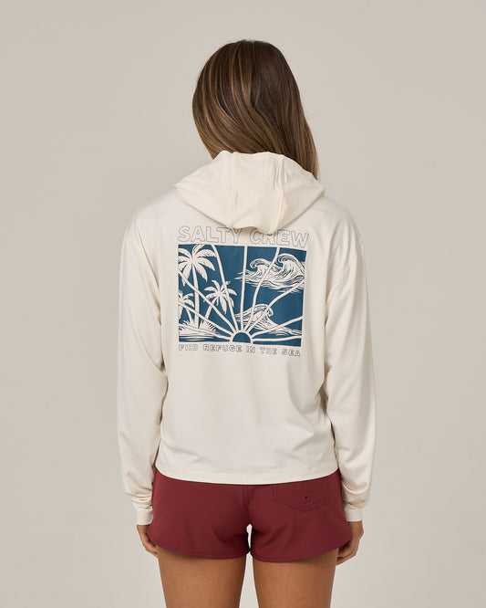 A person is shown from the back against a plain background, wearing the Salty Crew Island Wave Tech Hoodie in Off White—a skimmer length hoody featuring UPF 50+ sun protection and a blue graphic of waves, palm trees, and “SALTY CREW FIND REFUGE IN THE SEA” on the back. The look is paired with maroon shorts.