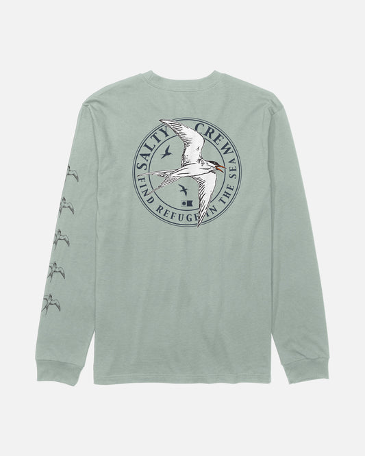 The Salty Crew Tern Long Sleeve Tee in Aqua Grey is a soft, combed ringspun cotton shirt with long sleeves. The back displays a circular “Salty Crew: Find Refuge in the Sea” logo featuring a flying tern, screenprinted for lasting quality. Smaller tern graphics are printed down the left sleeve, adding extra detail to this comfortable tee.
