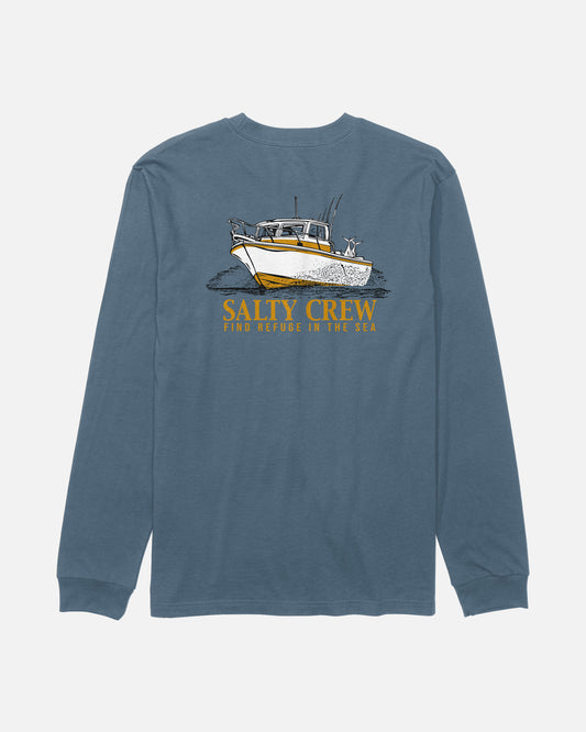 The Salty Crew Throttle Long Sleeve Tee in Slate is a blue cotton t-shirt featuring a screenprinted graphic of a fishing boat and a dog on the back, with yellow “SALTY CREW” text and smaller “FIND REFUGE IN THE SEA” text below the image.
