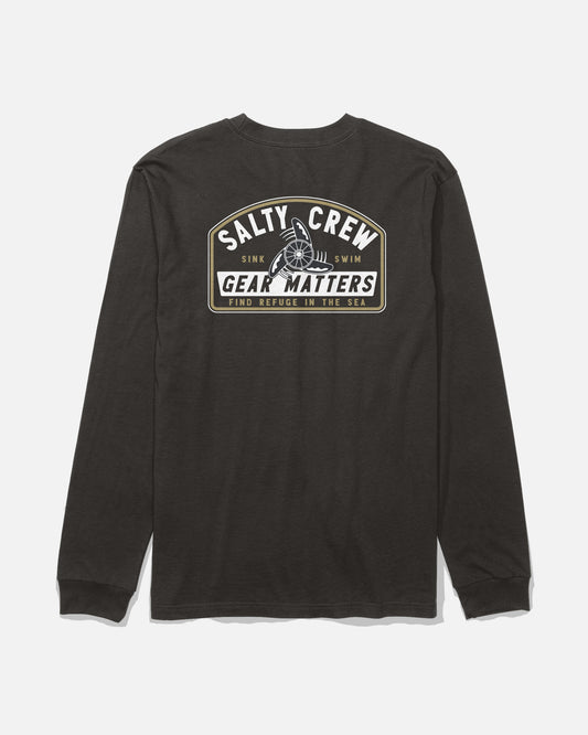 Introducing the Gear Shop Long Sleeve Tee - Black from Salty Crew. This long-sleeve cotton t-shirt showcases a ship wheel graphic and bold “Salty Crew Gear Matters” branding on the back, paired with the phrases “Sink or Swim” and “Find Refuge in the Sea” in crisp white and tan text. Made from soft combed ringspun fabric and completed with high-quality screenprinted details, this tee delivers both comfort and adventure-ready style.
