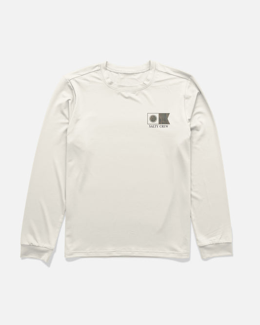 The Salty Crew Flagship Fill Boys Long Sleeve Sunshirt in Bone features a small Salty Crew logo and flag graphic on the left chest, crafted from lightweight, moisture-wicking fabric for all-day comfort.