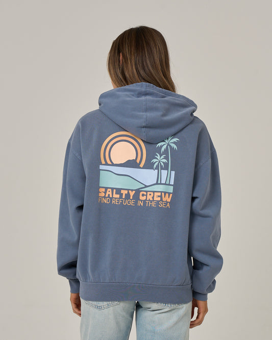 A person wearing the Salty Crew Sushi Roll Hoodie in Flint, featuring a sunset, palm trees, and the text “FIND REFUGE IN THE SEA” printed on the back, with a classic kangaroo pocket, standing against a plain background.