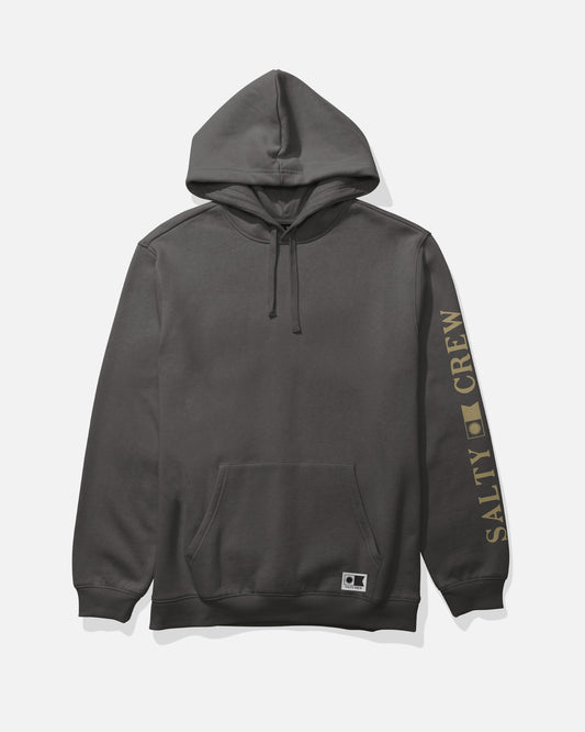The Salty Crew Refuge Fleece in dark grey is a cotton-polyester hoodie featuring a kangaroo pocket and an adjustable drawcord hood. Bold yellow “SALTY CREW” lettering and a square logo accent the right sleeve. The hoodie is shown against a plain white background.
