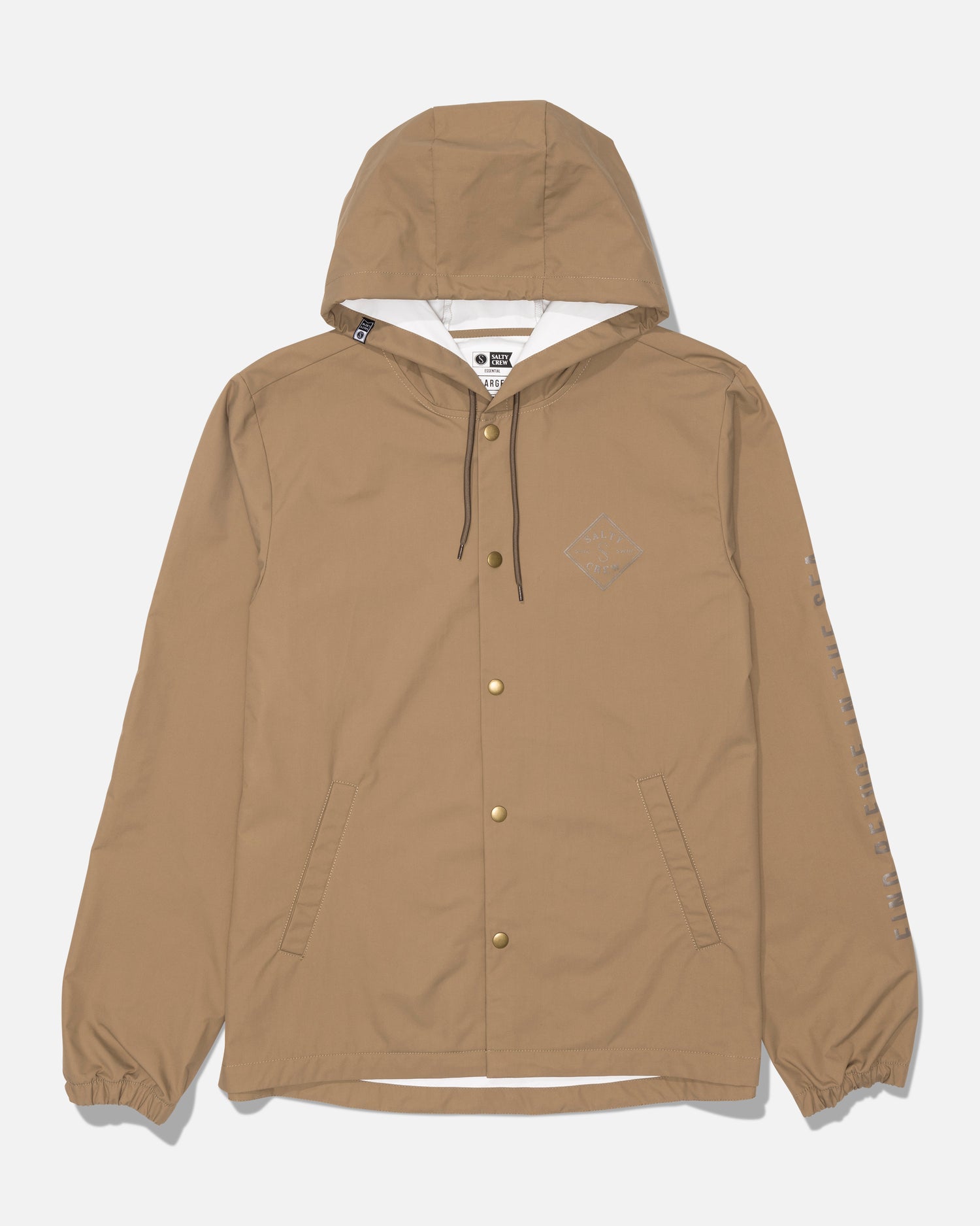 The Tippet Snap Jacket by Salty Crew in washed brown features a durable nylon shell, front snap buttons, two angled pockets, elastic cuffs, and black drawstrings. A small Salty Crew logo is screenprinted on the left chest, with text detailing running down the left sleeve.