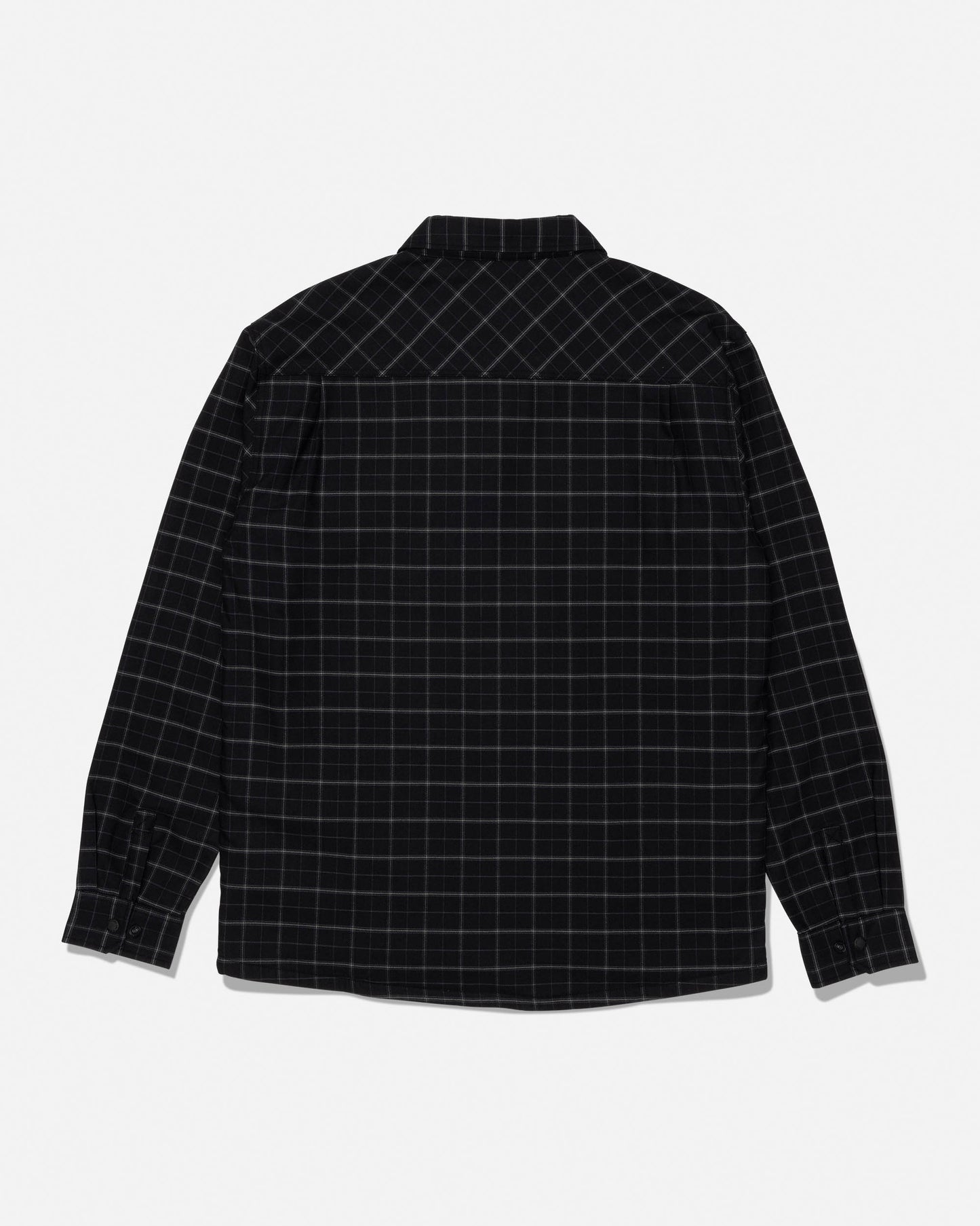 The Salty Crew Fathom Tech Shacket in Black/Green is displayed laid flat to showcase the back side. This long-sleeve, button-up shacket features a black base with a subtle green grid plaid pattern and is crafted from mid-weight twill with a cozy polar fleece liner for warmth and comfort.