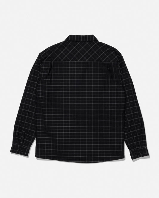 The Salty Crew Fathom Tech Shacket in Black/Green is displayed laid flat to showcase the back side. This long-sleeve, button-up shacket features a black base with a subtle green grid plaid pattern and is crafted from mid-weight twill with a cozy polar fleece liner for warmth and comfort.