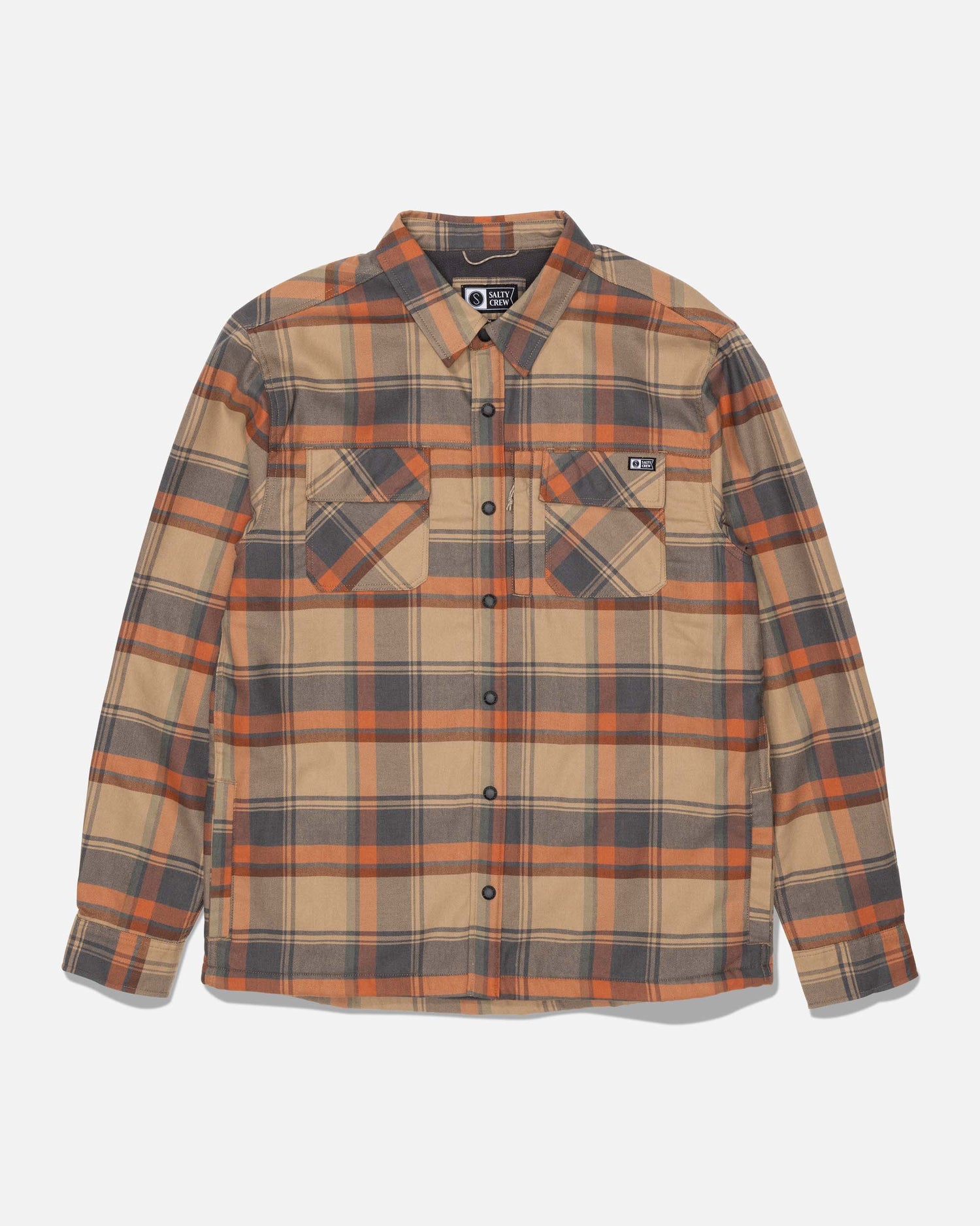 The Salty Crew Fathom Tech Shacket - Twig is a long-sleeve, button-up shirt featuring yarn-dyed plaid in shades of tan, orange, and gray, two chest pockets, and a cozy polar fleece liner, displayed on a plain white background.