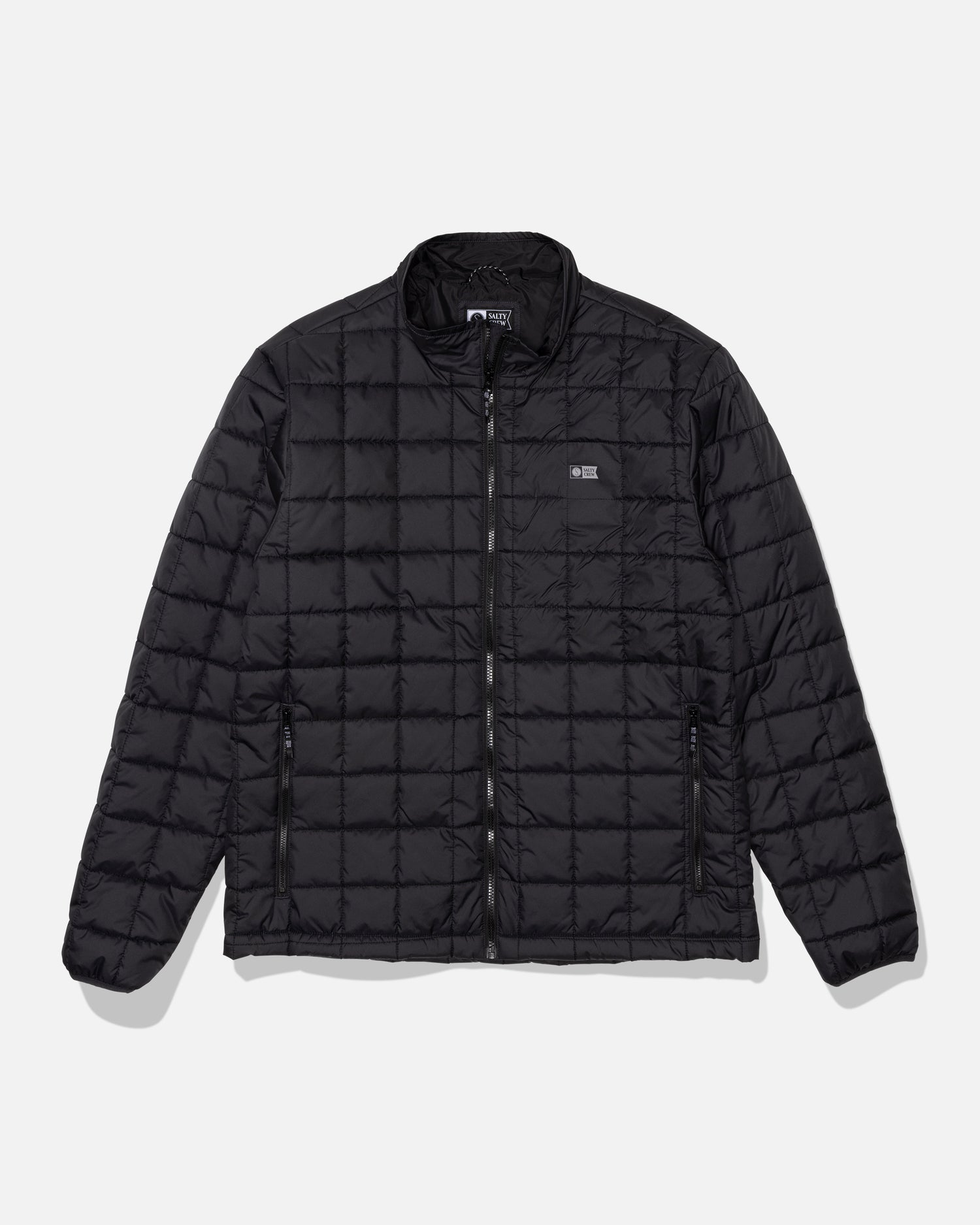 Introducing the Salty Crew Barrier Lite Jacket in black—a lightweight, water-resistant quilted jacket featuring a front zipper, two zippered side pockets, and a subtle chest logo. Designed with synthetic fill for added warmth, this jacket is shown on a white background.