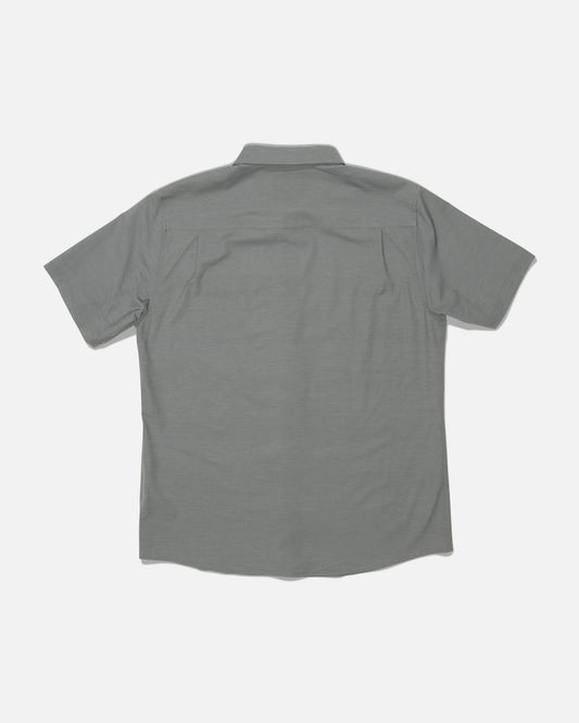The Salty Crew Drifter UV Button Up in Agave is displayed from the back on a white background. This gray short-sleeve shirt features a collar and a clean design with no visible logos or patterns. Made with quick dry fabric and advanced moisture wicking technology, it’s designed to keep you comfortable all day long.