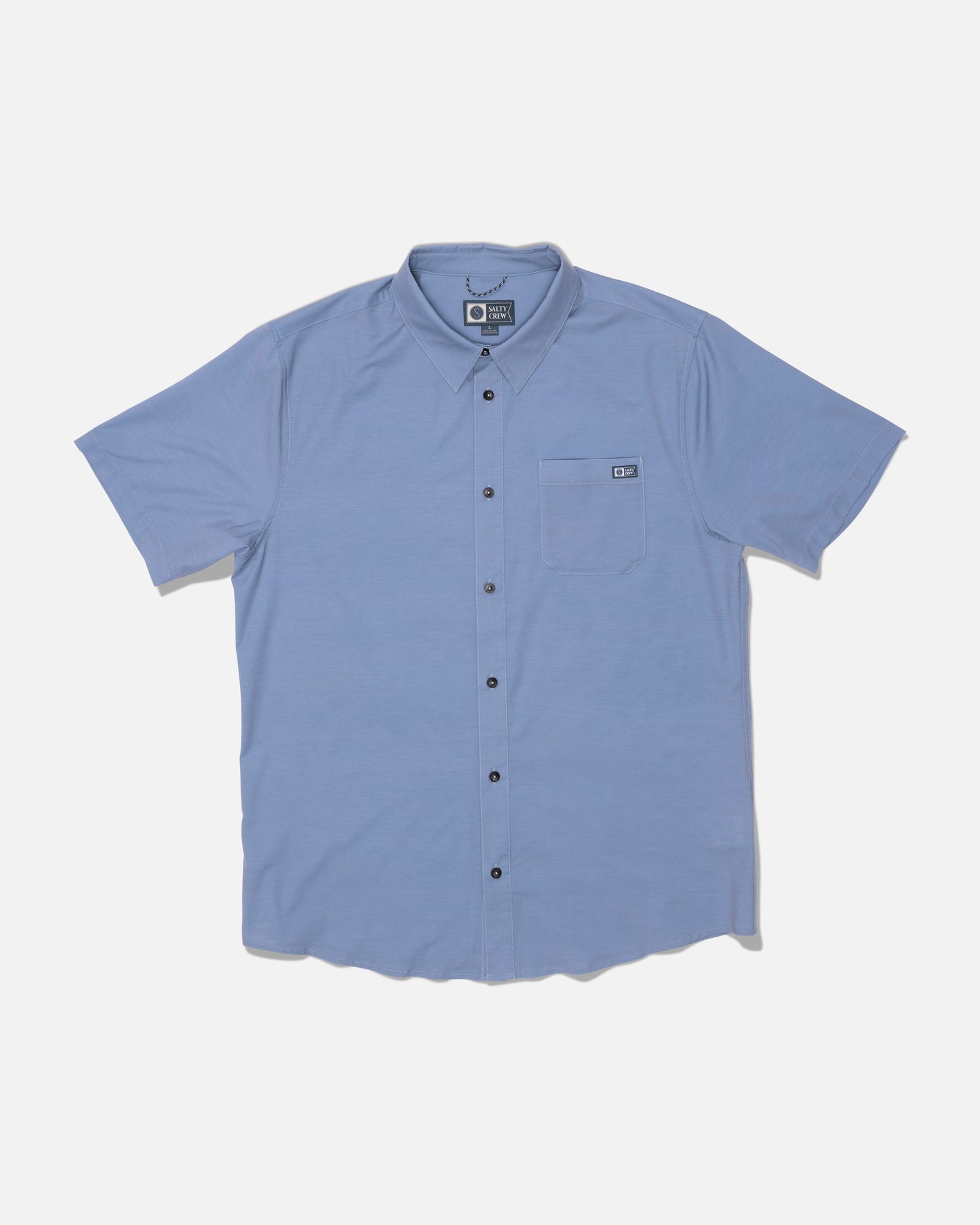 The Salty Crew Drifter UV Button Up in Hitch Blue is a light blue short-sleeve shirt featuring dark buttons and a left chest front pocket. Designed for all-day comfort with quick dry performance, it’s shown laid flat on a white background.