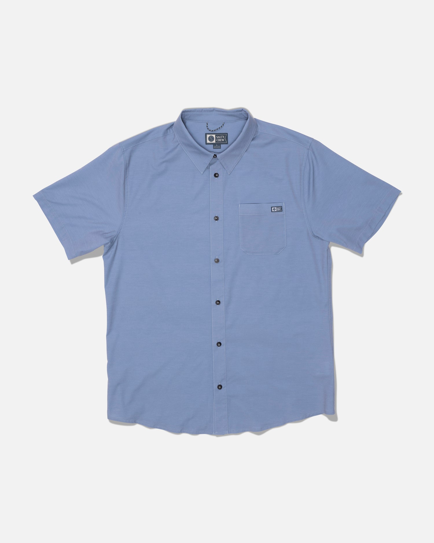 The Salty Crew Drifter UV Button Up in Hitch Blue is a light blue short-sleeve shirt featuring dark buttons and a left chest front pocket. Designed for all-day comfort with quick dry performance, it’s shown laid flat on a white background.
