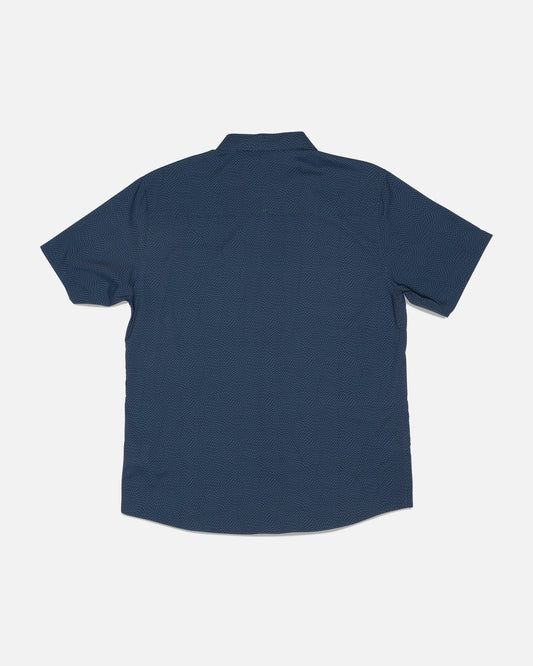 Back view of the Salty Crew Flagship UV Button Up in Mid Blue, a short-sleeve shirt featuring a subtle dotted pattern, laid flat on a white background. Made with quick-dry, moisture-wicking fabric for all-day comfort.