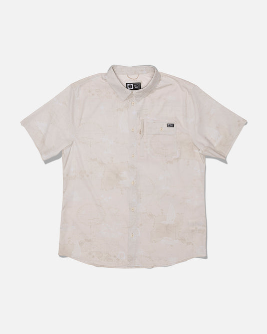 The Salty Crew Flagship UV Button Up in Off White is a short-sleeve shirt featuring a subtle pattern, front chest pocket with a small black label, and moisture-wicking properties to keep you cool and dry. Designed for comfort and functionality, this button-up is laid flat on a white background.