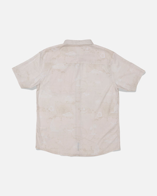 The Salty Crew Flagship UV Button Up in Off White is a short-sleeve, light-colored shirt displayed flat with the back facing up. It features a collar, straight hem, and a subtle, barely visible pattern. Engineered for all-day comfort in any climate, this button-up offers quick-dry performance and UPF 50+ sun protection.