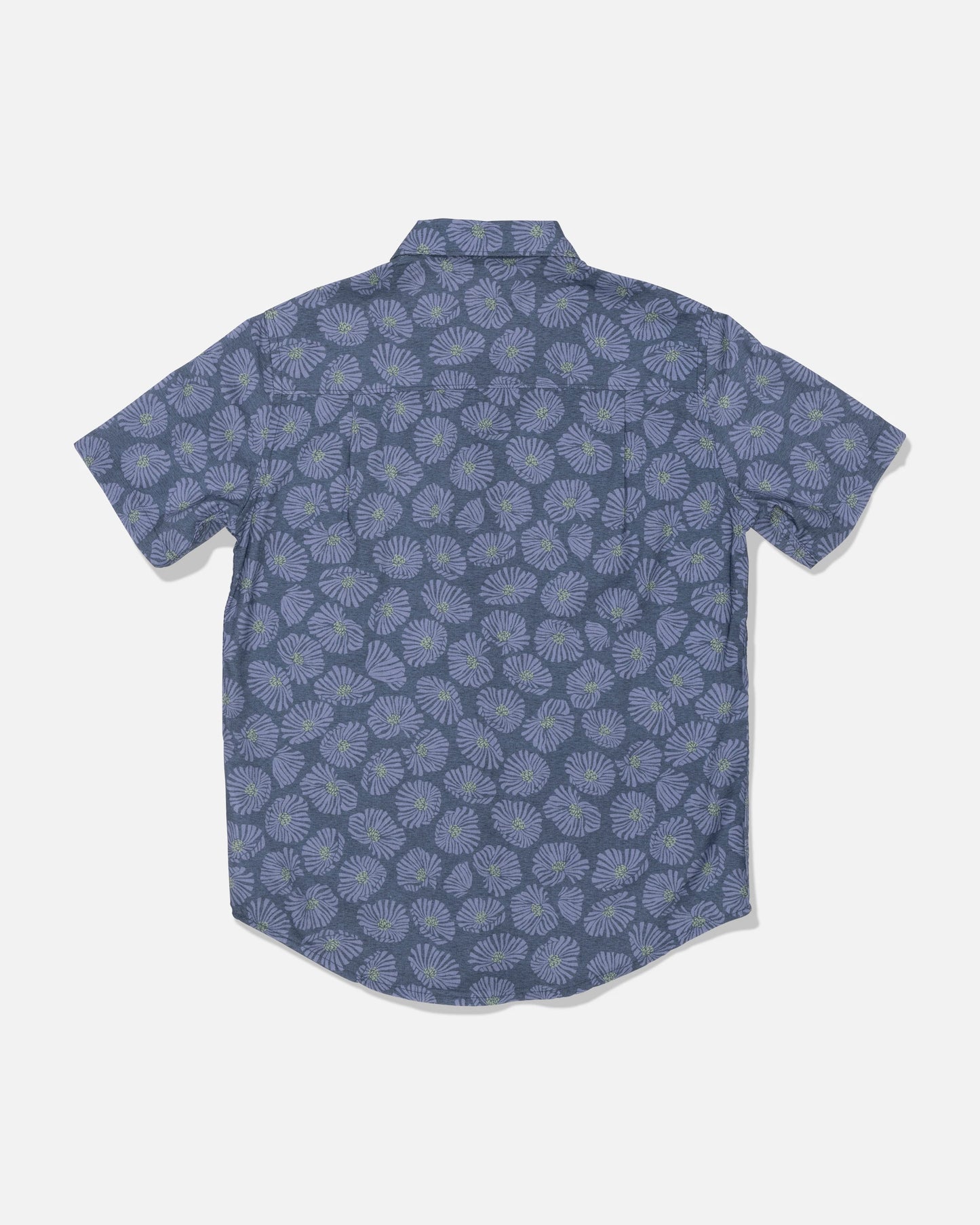 The Salty Crew Crew Boys Button Up in Hitch Blue is a short-sleeve, button-up shirt made from a soft cotton blend, featuring an allover print of light blue and green floral designs on a blue background. The shirt is displayed from the back against a plain white backdrop.