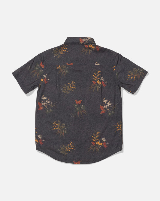 A rear view of the Salty Crew Crew Boys Button Up in Off Black, a short-sleeve cotton blend shirt featuring a subtle allover floral and butterfly print in muted orange, yellow, and cream tones.
