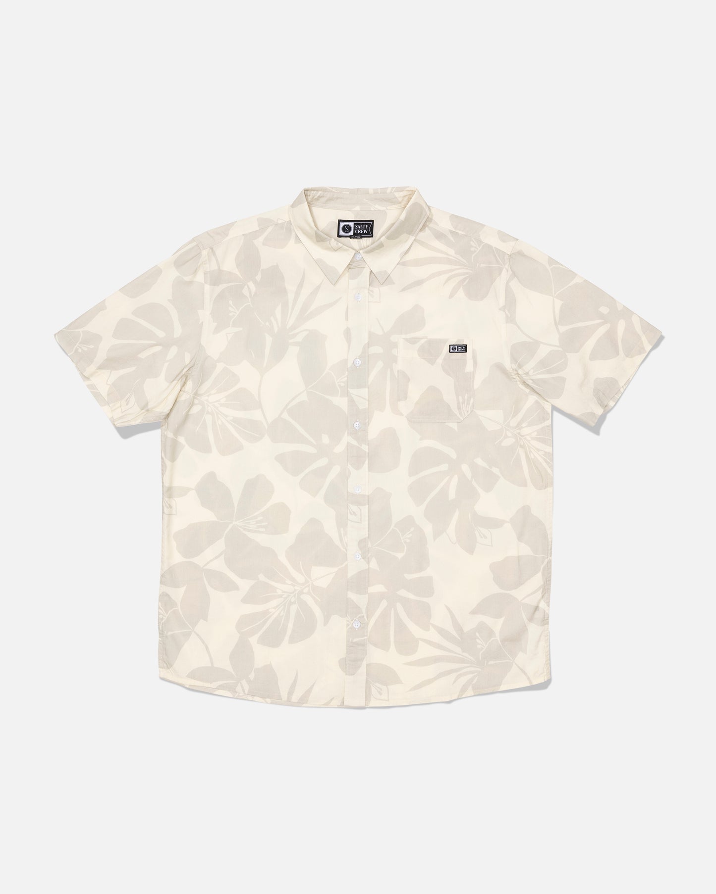 Introducing the Salty Crew Crew Button Up - Birch: a short-sleeve, button-up shirt crafted from a comfortable cotton blend in a cream birch shade. It features a subtle allover leaf print, a small chest pocket detailed with a black and white Salty Crew label, and is finished with a soft garment wash for added comfort.