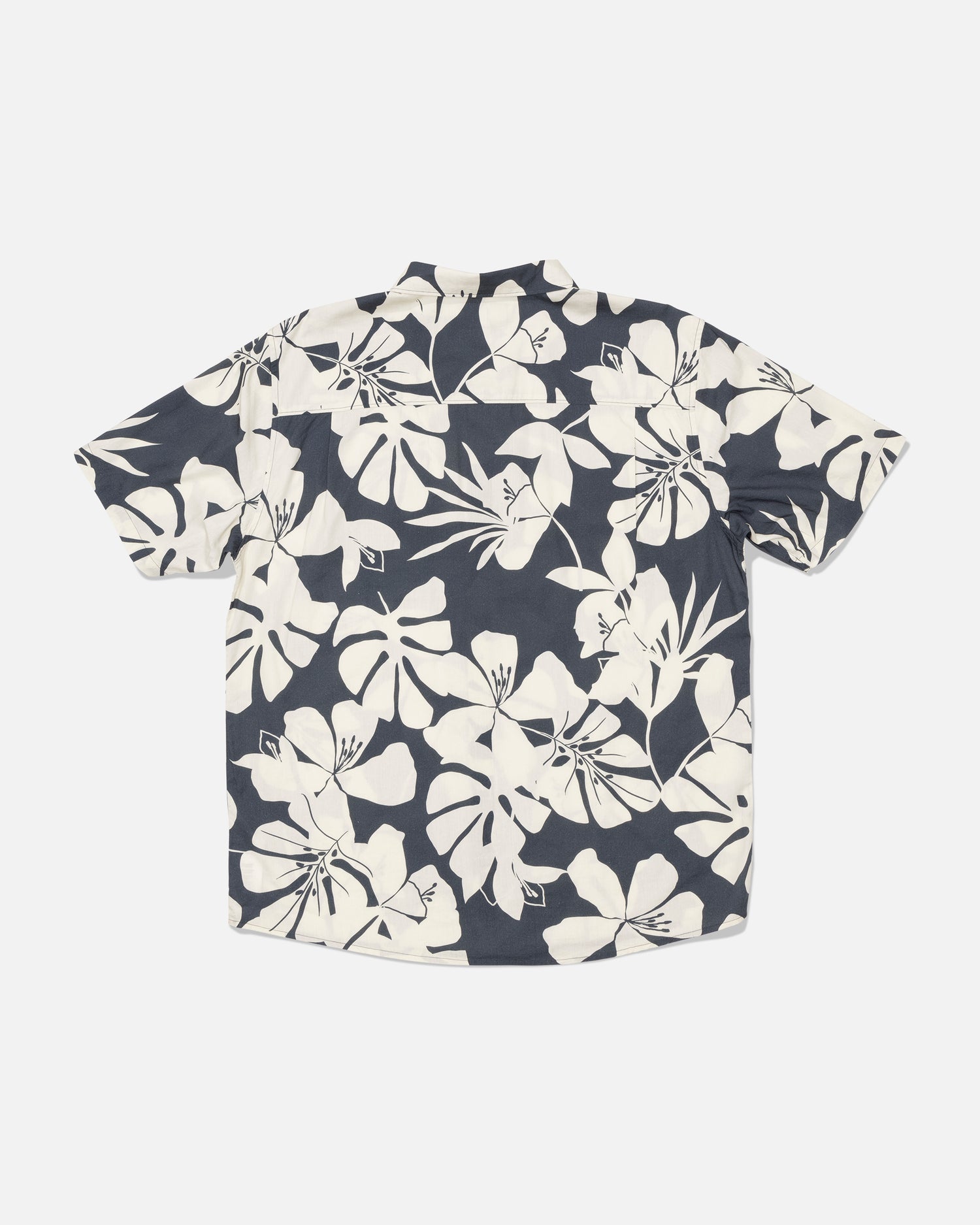 The Salty Crew Crew Button Up - Iron is a short-sleeve shirt made from a soft cotton blend, featuring a black background with a bold white tropical floral allover print, shown laid flat with the back side facing up.