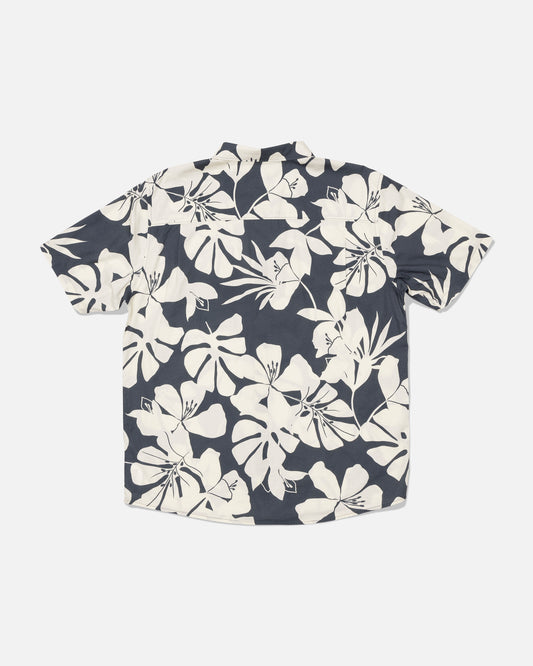 The Salty Crew Crew Button Up - Iron is a short-sleeve shirt made from a soft cotton blend, featuring a black background with a bold white tropical floral allover print, shown laid flat with the back side facing up.