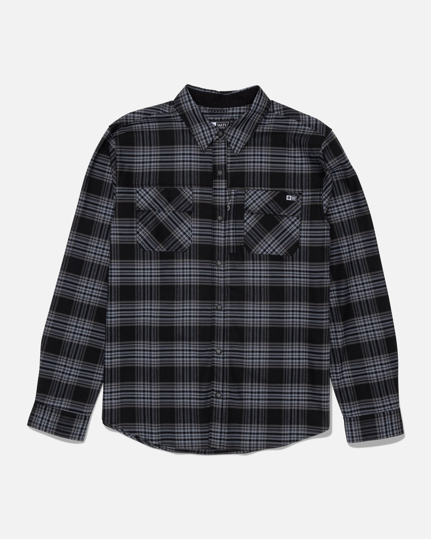 The Salty Crew Fathom Tech Flannel - Dark Grey is a long-sleeve, button-up mid-weight twill shirt with a yarn-dyed black, gray, and white plaid pattern. It features two front chest pockets and a collar, shown laid flat on a white background.