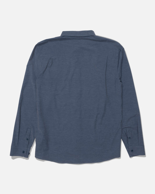 A Salty Crew Drifter Long Sleeve UV Button Up in navy/grey is laid flat with the back side facing up, showcasing a simple design with a collar and button cuffs, free from visible patterns or logos. Made with moisture-wicking fabric, this shirt keeps you comfortable all day long.