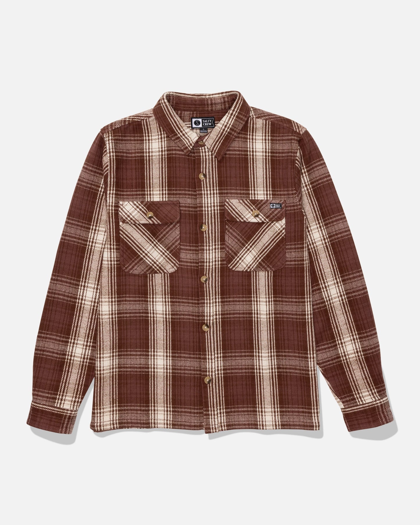 The Salty Crew Windward Flannel - Deep Brown is a long-sleeve button-up shirt made from heavyweight cotton twill in a deep brown and cream plaid, featuring two chest pockets with button flaps and finished with a garment wash for added softness.