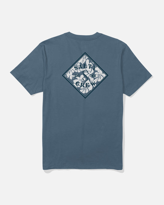 The Salty Crew Tippet Fill Crew Tee in Slate Blue is crafted from soft combed ringspun cotton for all-day comfort. This tee features a diamond-shaped, screenprinted back graphic with white leaves and the words “SHARK CREW” in dark blue, arranged around a shark silhouette.