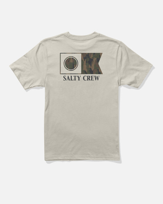 The Flagship Boys Tee in Bone by Salty Crew features a beige cotton fabric with a camo-printed nautical flag graphic and “SALTY CREW” text screenprinted on the back.