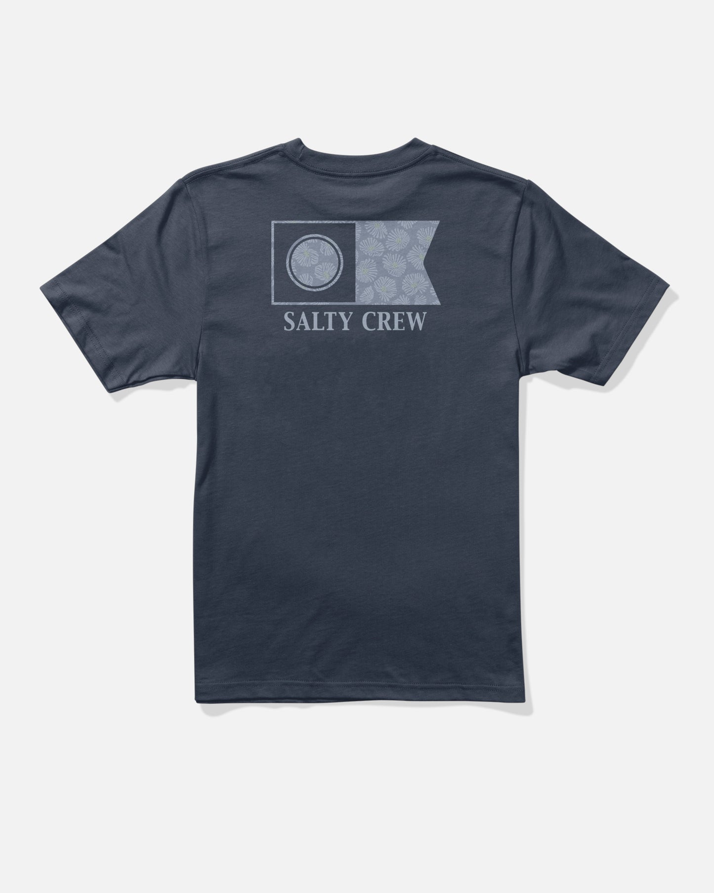 The Salty Crew Flagship Boys Tee in Navy is pictured from the back, displaying a screenprinted logo at the center. The rectangular flag design features a circular emblem on the left and a floral pattern on the right, with “SALTY CREW” text beneath. Made from soft combed ringspun cotton, this t-shirt provides both comfort and style.