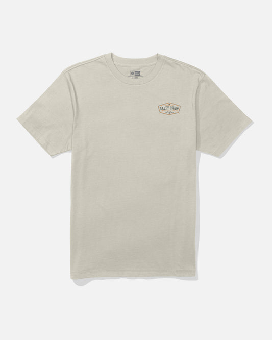 The Salty Crew Tailfin Crew Tee in Bone is a beige short-sleeve t-shirt featuring a small Salty Crew logo on the left chest. Made from soft combed ringspun cotton, this tee is shown laid flat on a white background.