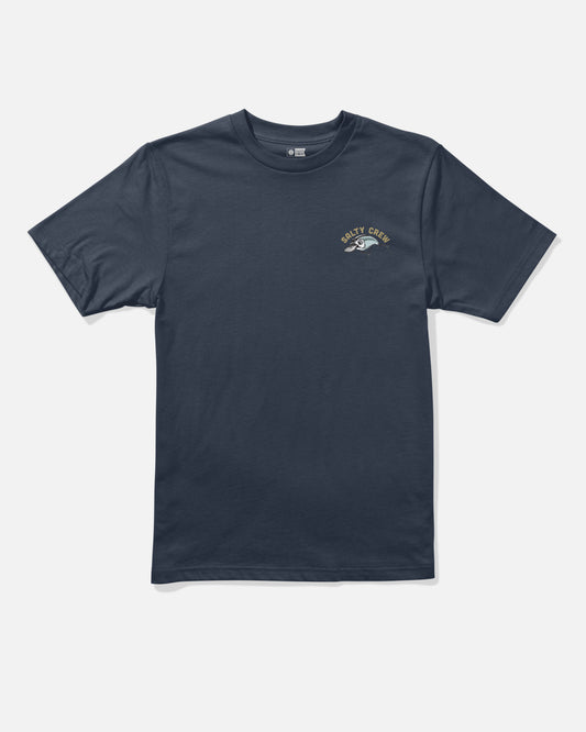 The Salty Crew Catch Me Boys Tee in navy is a short-sleeve, crew neck t-shirt displayed on a plain light grey background. Crafted from soft combed ringspun cotton for durability and comfort, it features a small screenprinted fishing lure graphic and “SALTY CREW” in a curved gold font on the left chest.