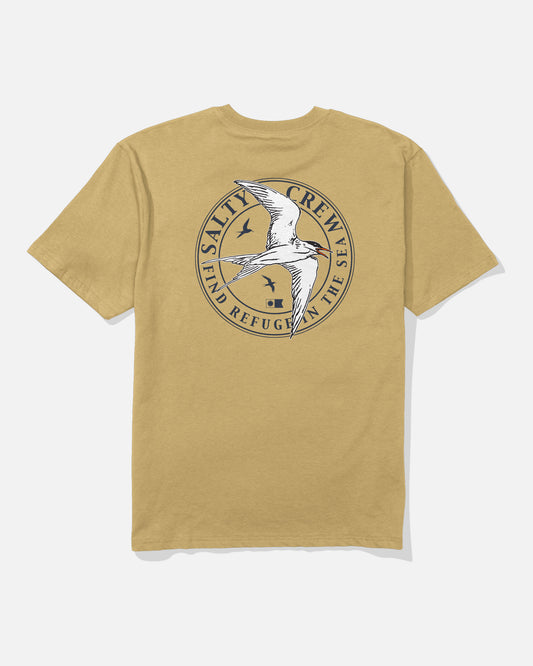 The Salty Crew Tern Original Tee in Mineral Yellow features a circular, screenprinted logo on the back depicting a flying bird with two smaller birds and the text “Salty Crew” and “Find Refuge in the Sea.” Crafted from soft spun cotton for ultimate comfort.