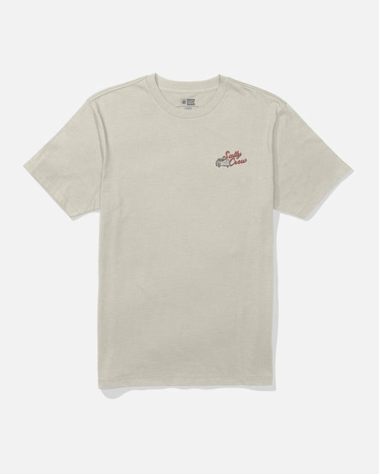 The Salty Crew Truck Bed Crew Tee in Bone is a beige short-sleeve combed ringspun cotton t-shirt featuring a small red and brown screenprinted graphic and text on the left chest, shown laid flat on a plain white background.