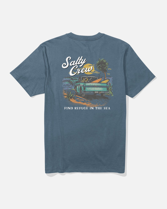 Slate-colored Truck Bed Crew Tee by Salty Crew, made from combed ringspun 100% cotton, featuring a screenprinted graphic of a van with a surfboard, palm trees, and sunset. Text reads “Salty Crew” and “Find Refuge in the Sea.”.