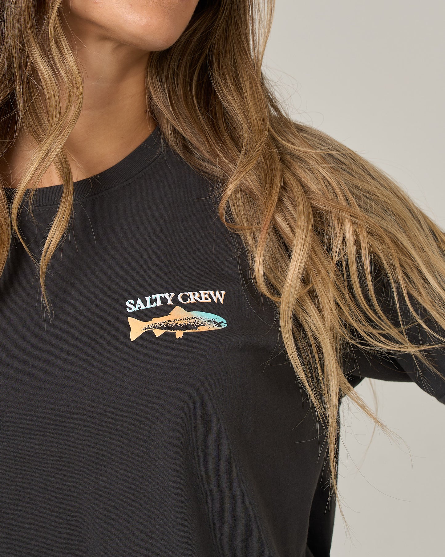 Close-up of a charcoal Daily Catch Boyfriend Tee featuring a chest graphic of a fish silhouette and the text SALTY CREW.