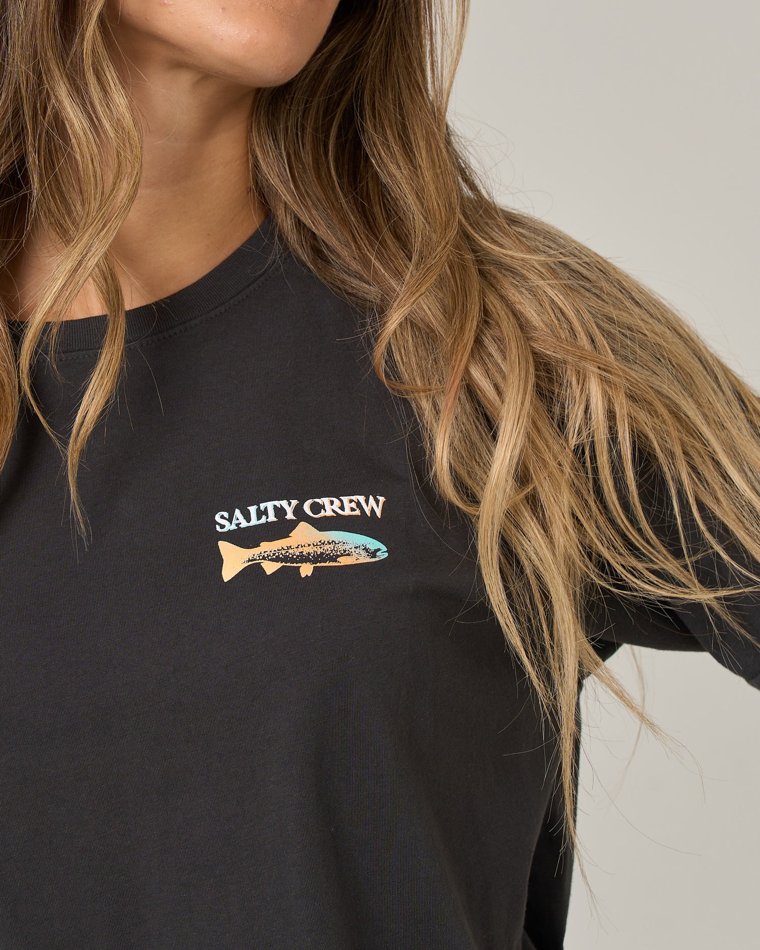 Close-up of a charcoal Daily Catch Boyfriend Tee featuring a chest graphic of a fish silhouette and the text SALTY CREW.