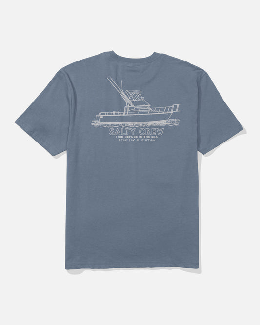 The Salty Crew Vessel Heavyweight Tee in washed blue features a white fishing boat line drawing and "SALTY CREW Find Refuge In The Sea" on the back. The shirt is shown laid flat on a white background.