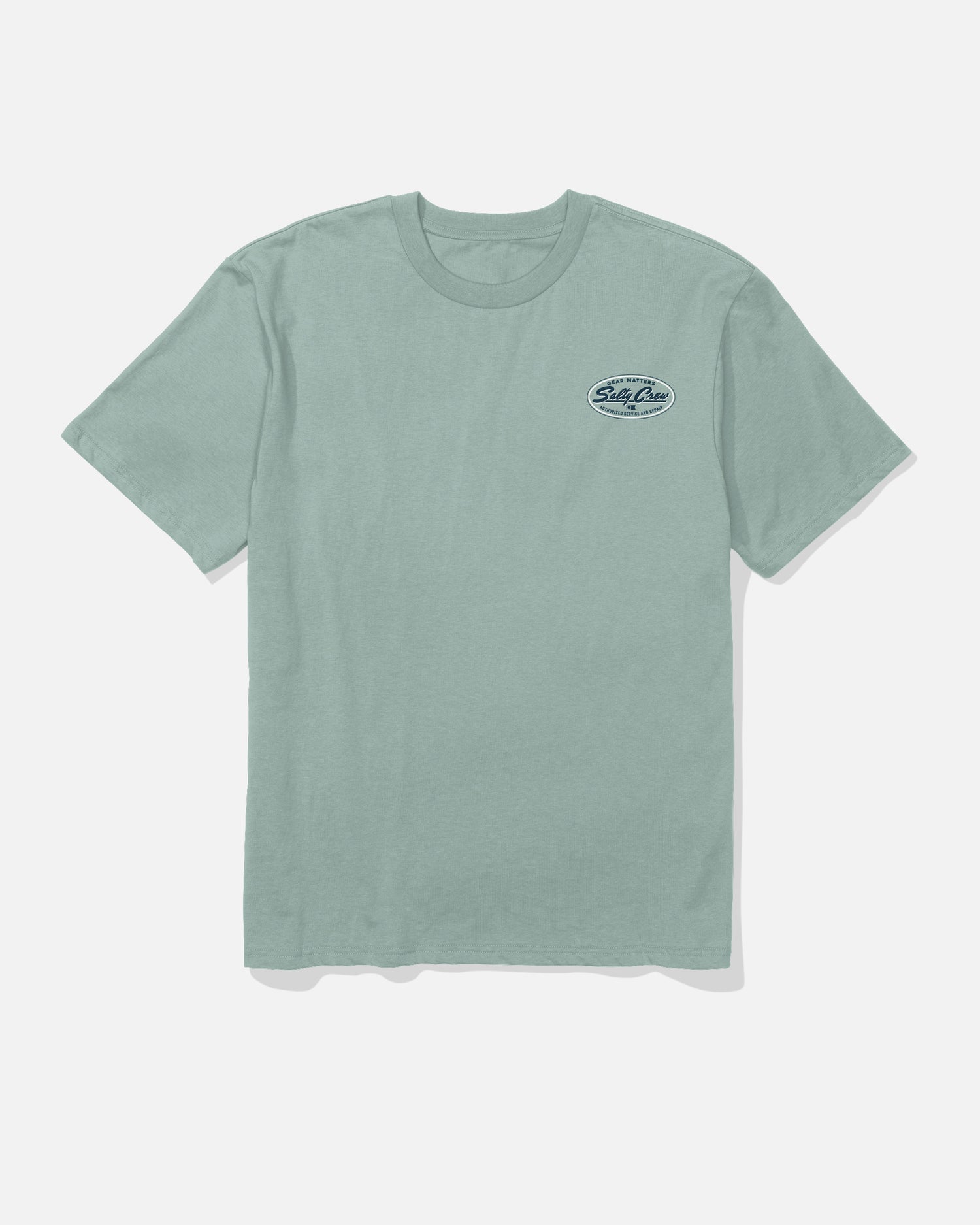 The Service Heavyweight Tee by Salty Crew is a washed steel grey short-sleeve shirt with a small oval logo on the upper left chest. It’s displayed flat against a plain white background.