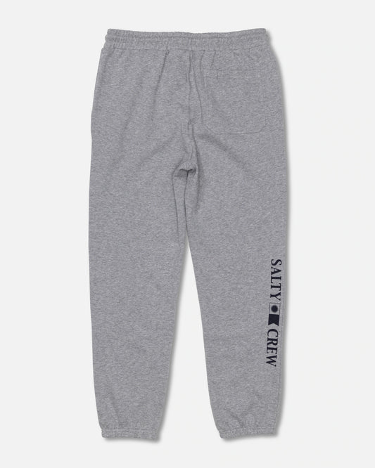The Salty Crew Crewser Fleece Pant in Athletic Heather is shown laid flat on a white background. These gray sweatpants feature an elastic waistband and cuffs, with “SALTY CREW” screenprinted along the leg and a small black Salty Crew logo printed on the lower left side.