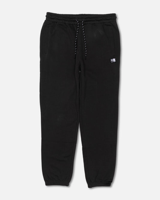 The Salty Crew Crewser Fleece Pant in Pirate Black features an elastic waistband with a drawstring, side pockets, and elastic cuffs at the ankles. These sweatpants are detailed with a small rectangular patch on the left side and subtle screenprinted artwork. Shown laid flat on a white background.